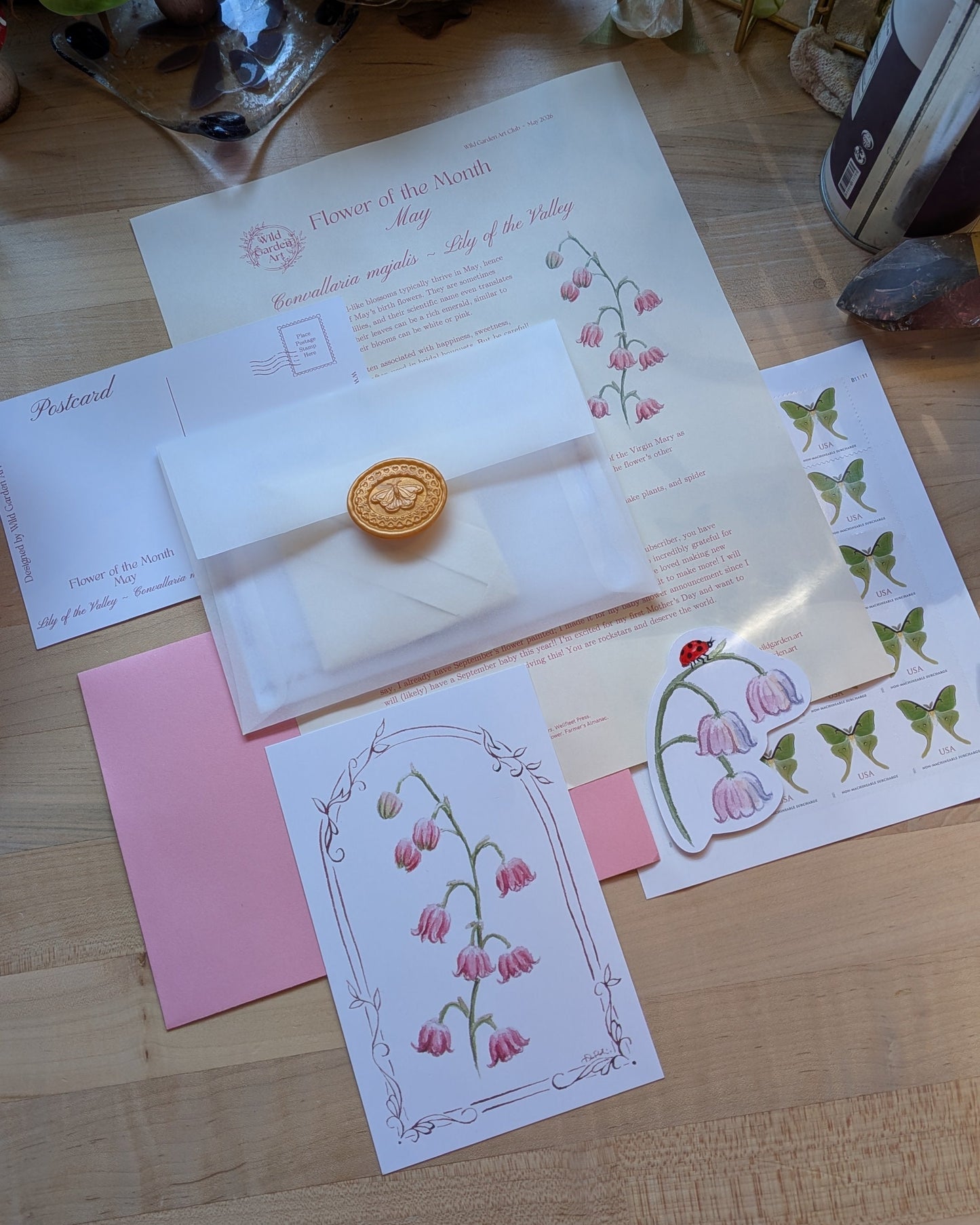 Collection of stationery items including cards and an envelope with a wax seal on a wooden surface.