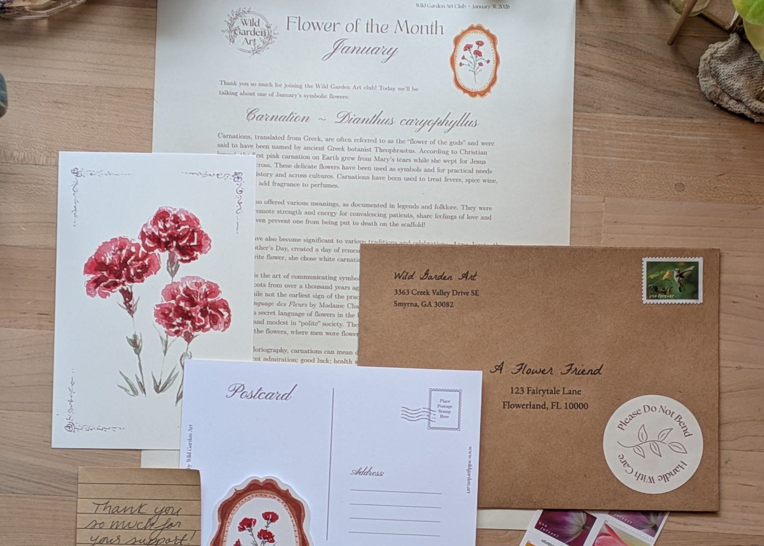 Collection of stationery items including letters, postcards, and stamps on a wooden surface.